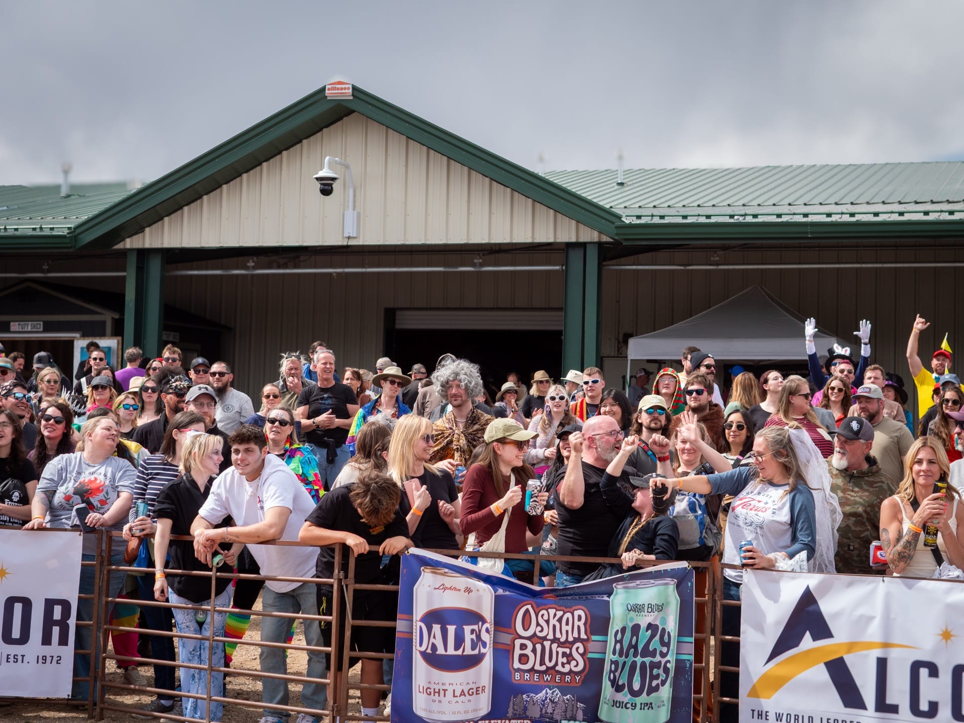 Spectators crowd the rail along the coffin course beside sponsor banners.