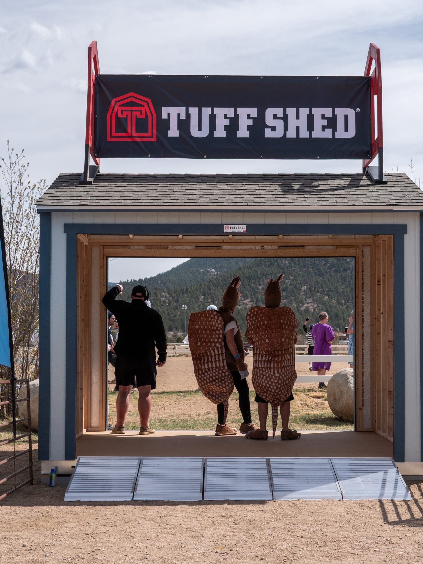 A Tuff Shed display on the festival grounds, with costumed guests inside.