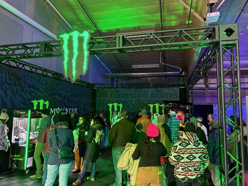 Guests explore the Monster Energy area under green lights.