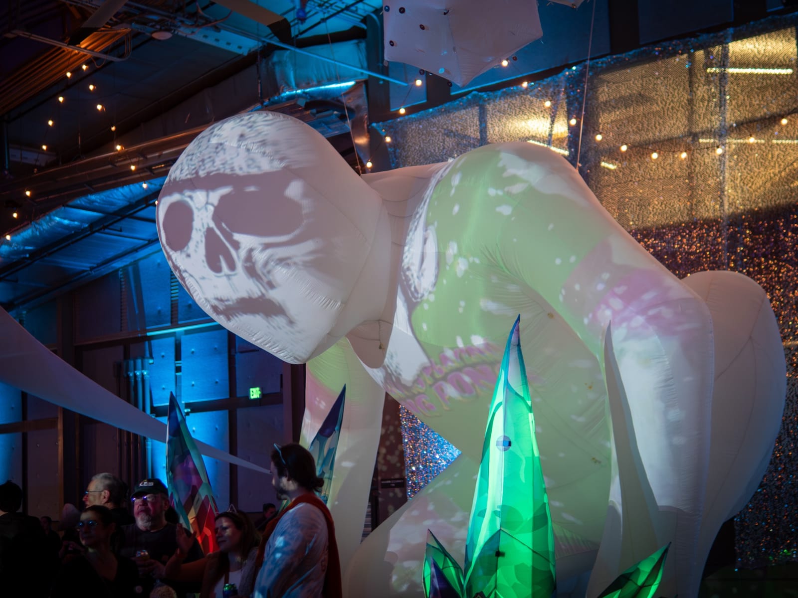 A giant inflatable skull glows under blue lights inside the festival hall.