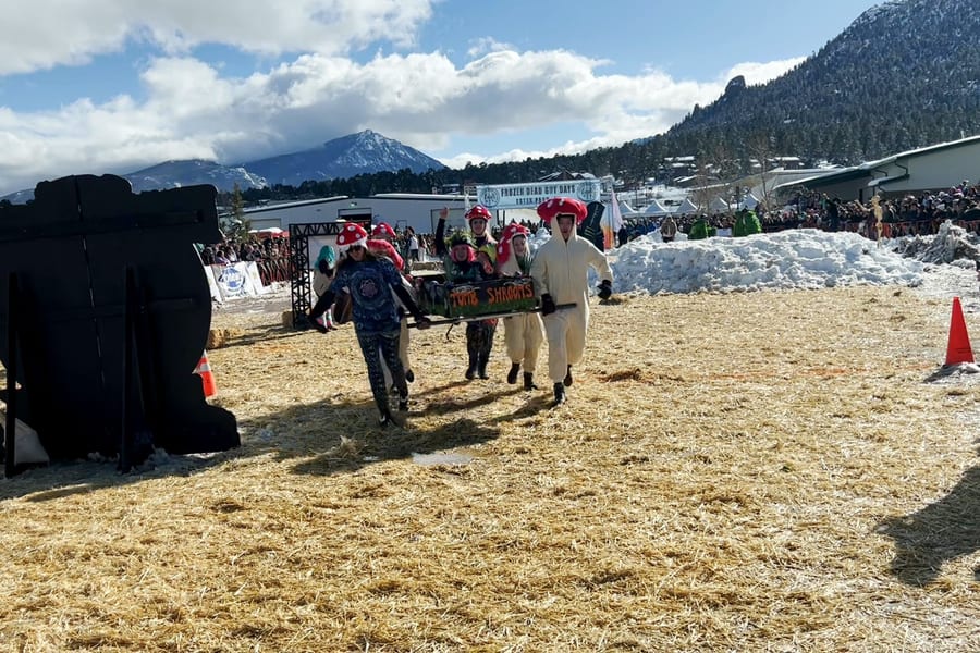 Tomb Shrooms, in red-and-white mushroom hats and white suits, charge across the straw-covered course with their coffin, snowbanks and peaks behind.