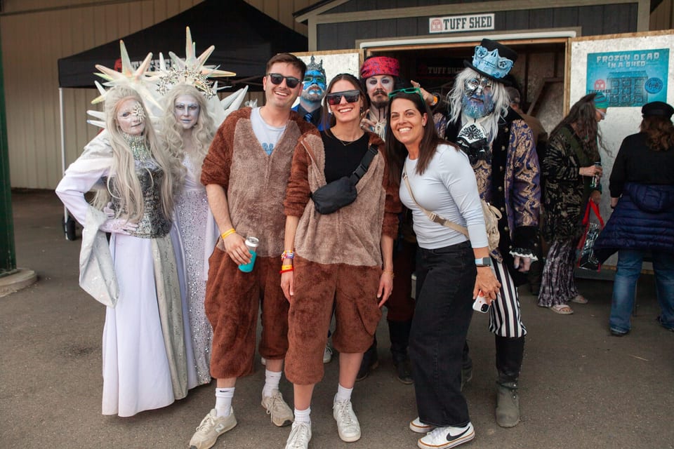Two Ice Queens and two frozen grandpas pose with three smiling festival-goers at the Tuff Shed shed.