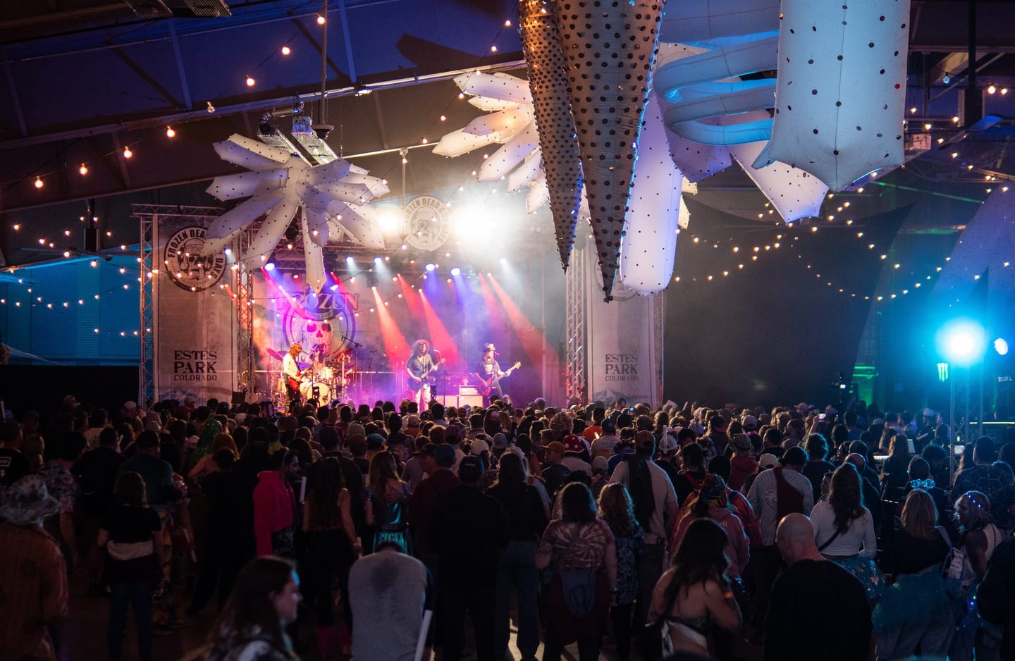 Pigeons Playing Ping Pong play the Ice Room Stage through red and blue beams and haze, a packed crowd under giant ice-crystal inflatables.
