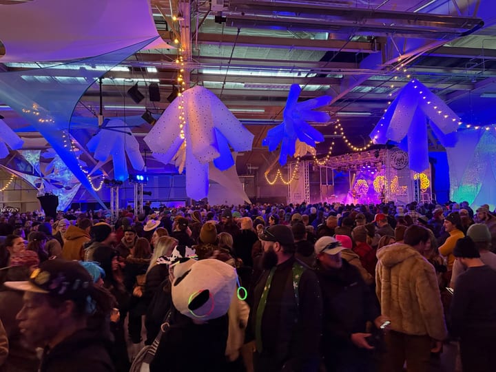 The whole Ice hall: inflatables overhead, the stage glowing and the floor packed.